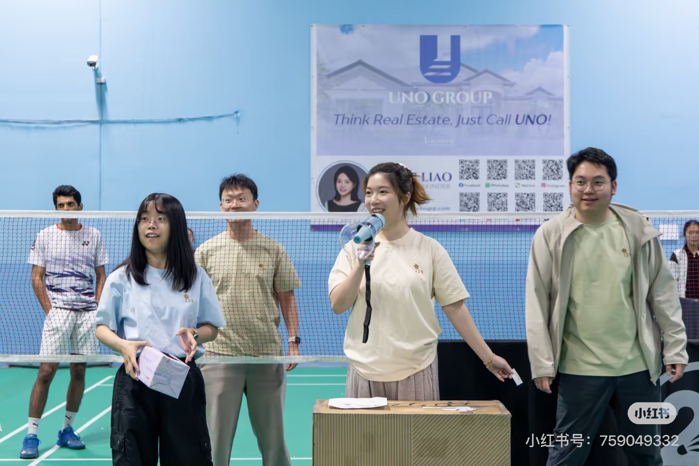 Tournament organizers running the prize raffle with a megaphone in front of the UNO Group banner